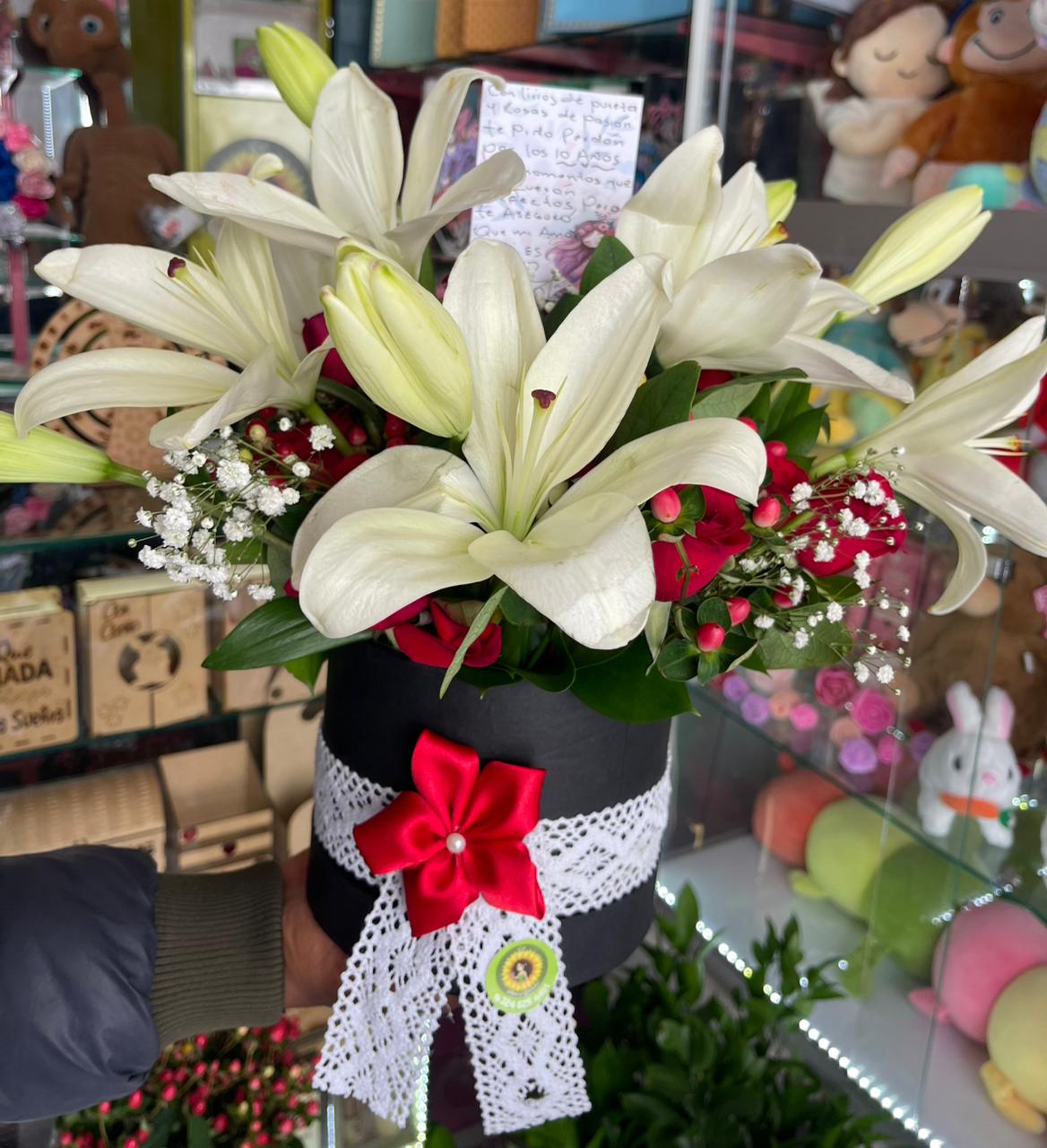 Lirios blancos en caja negra redonda